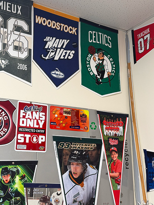 Wall of sports pennants and posters, including Woodstock Navy Vets and Boston Celtics banners