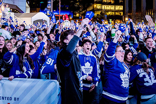 Toronto Maple Leafs fans cheering at an outdoor watch party
